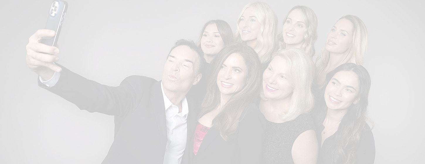 Group selfie of smiling people in formal attire.