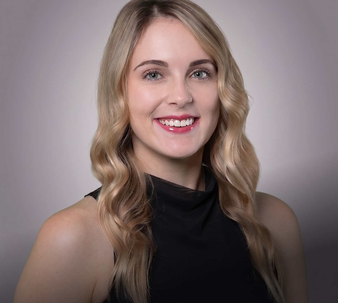 Smiling woman with wavy blonde hair.