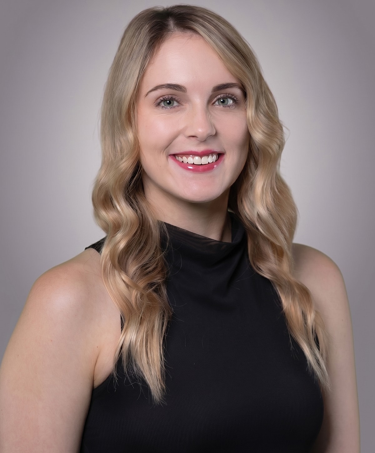 Healthcare professional holding a syringe and smiling.
