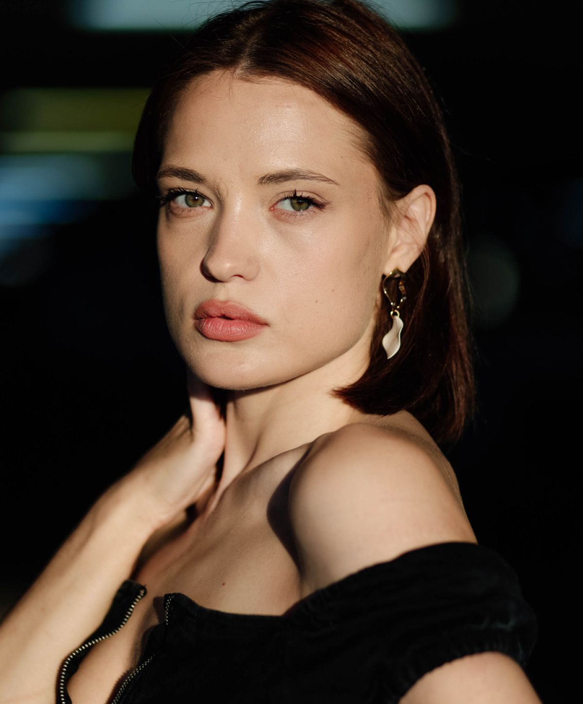 Woman with piercing green eyes in soft lighting.