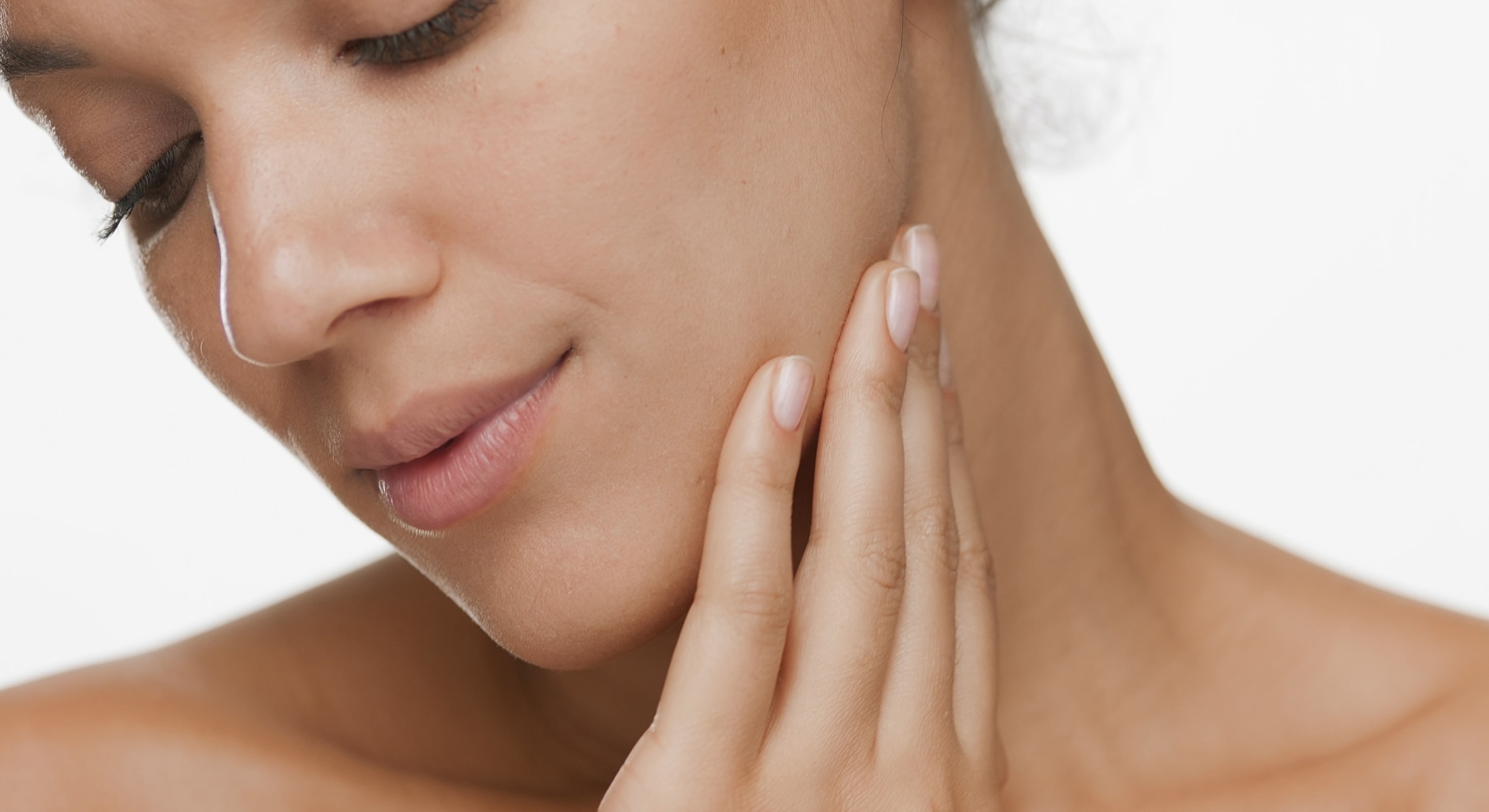 Woman touching her face gently.