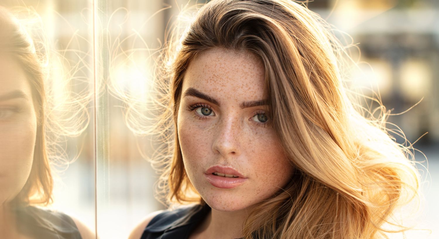 Close-up of a young woman with freckled skin.