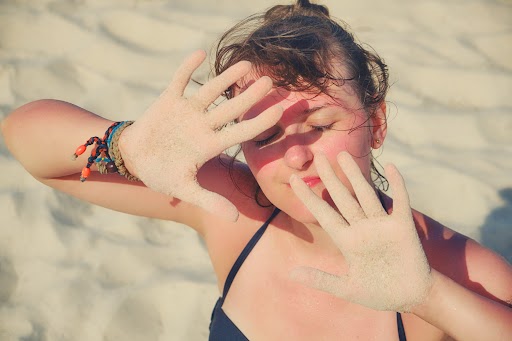 Girl put her hands in front of her face for protection from the sun | Patrick Bitter MD in Los Gatos, CA