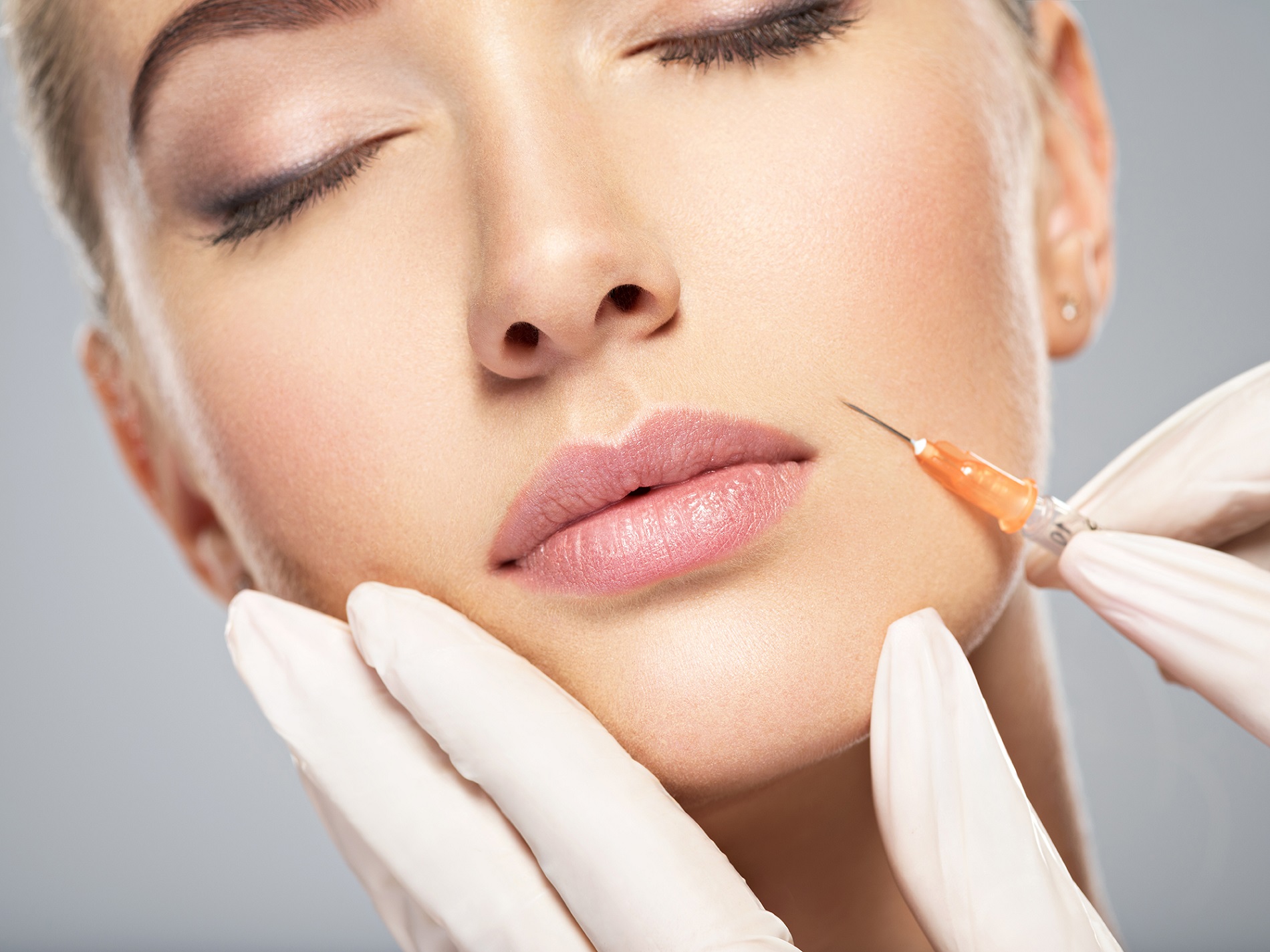 Close up portrait of blonde woman with cosmetologist hands giving botox injection | Patrick Bitter MD in Los Gatos, CA